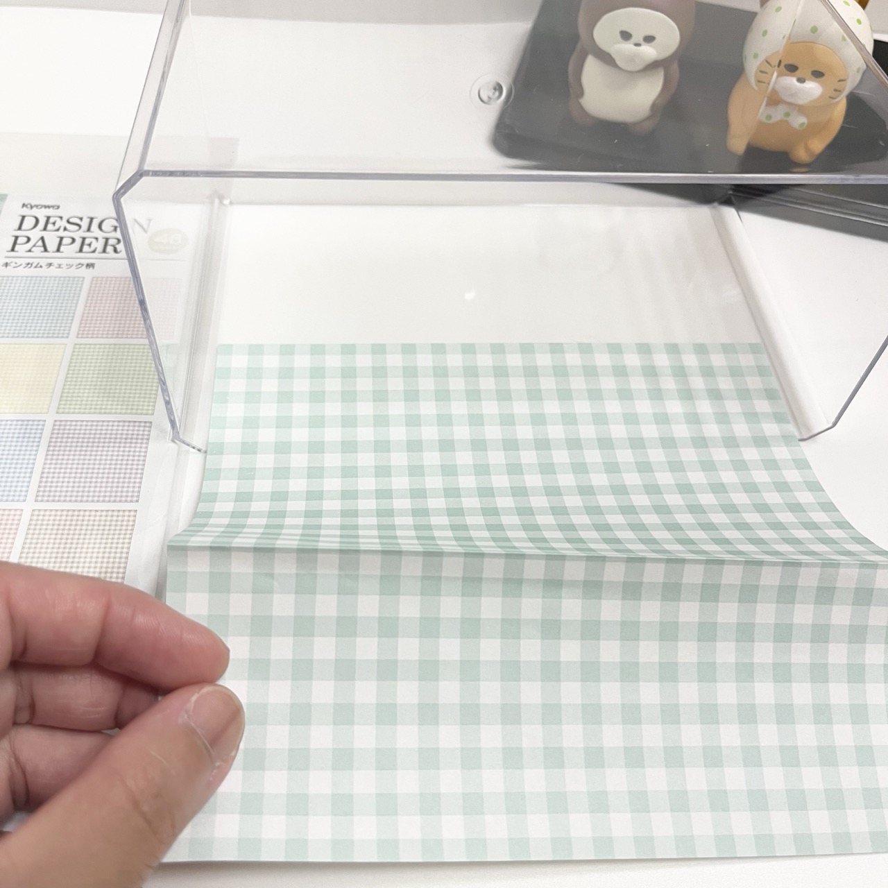 ディスプレイケースの背景にデザインペーパーを合わせているところ