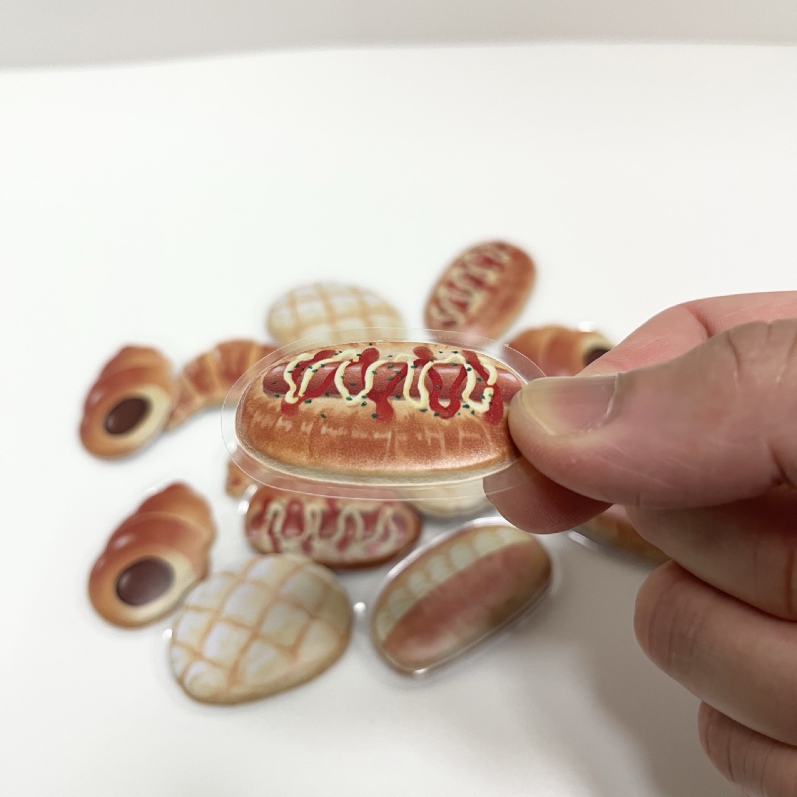 パンのフレークシール ウインナーパンを手に持ったところ